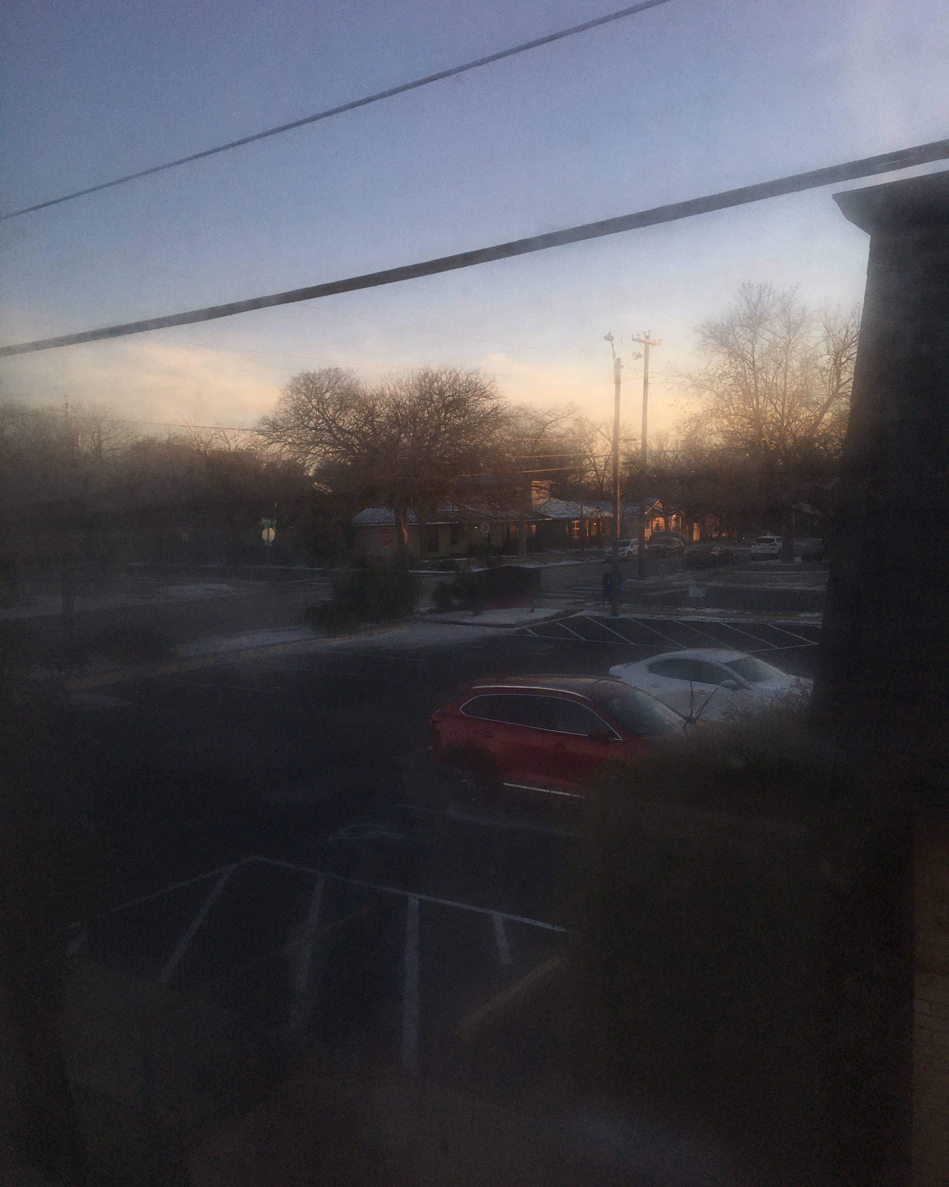 looking out a fogged window onto a snowy intersection