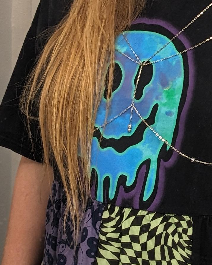 zoomed in picture of a tshirt with a melting smiley face graphic